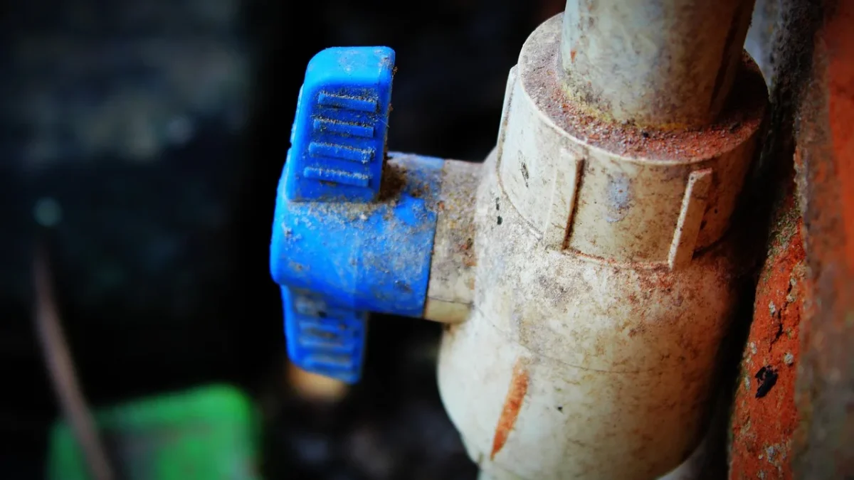 A digital tap timer screwed onto an outdoor garden faucet with a drip line attached
