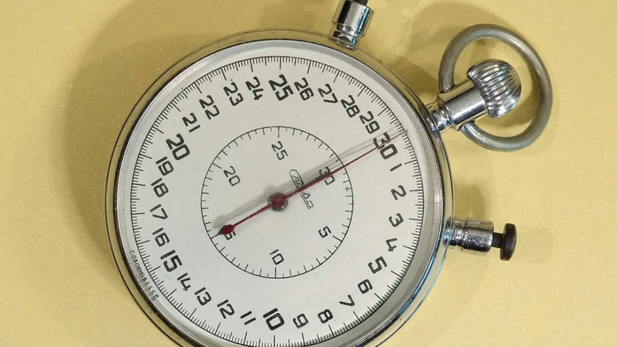 A mechanical spring-dial hose timer attached to an outdoor faucet